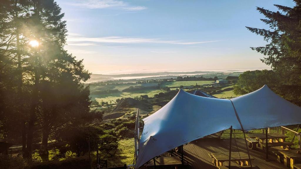 a white tent sitting on top of a hill at Wheal Tor Hotel & Glamping in Liskeard