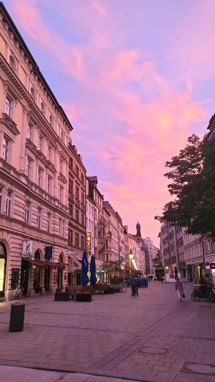 a city street with buildings and a cloudy sky at Hotel Atlanta in Munich