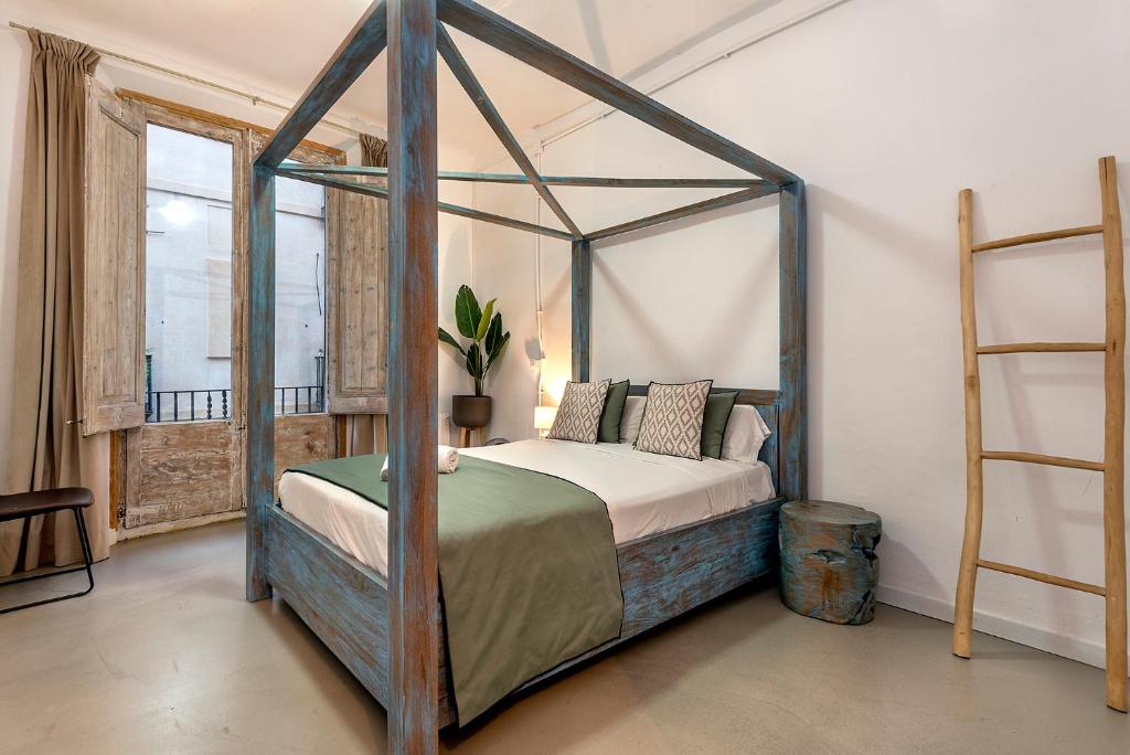 1 dormitorio con cama con dosel y escalera en La Guarida Suites, en Barcelona
