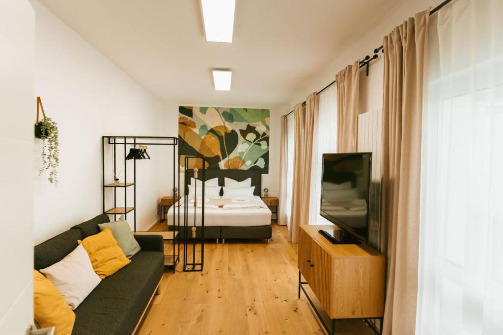 sala de estar con sofá y cama en Staylight City-Loft, privater Parkplatz, Nähe zur Messe und der City, Premium Appartements, en Hannover
