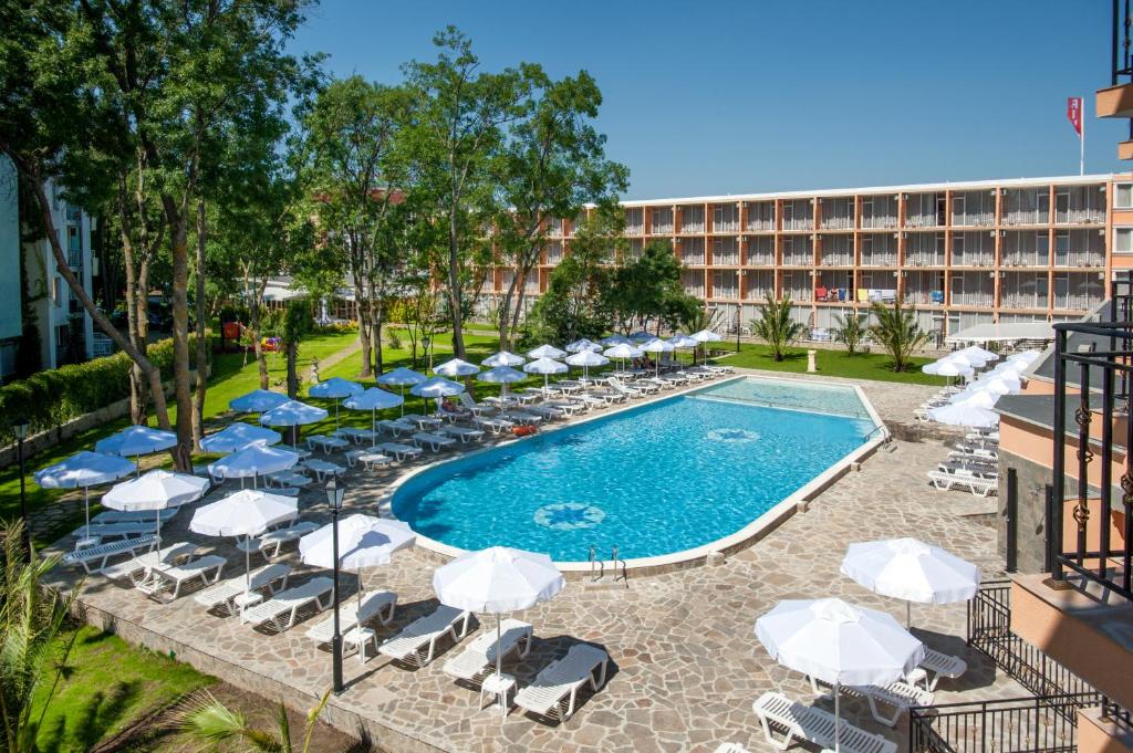 una piscina con sillas y sombrillas y un hotel en Hotel Riva - All Inclusive, en Sunny Beach