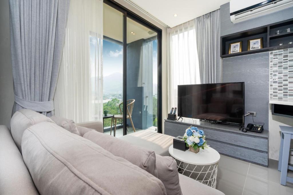 a living room with a couch and a flat screen tv at Citygate Condo L704, near FantaSea & Café Del Mar Kamala Beach Club in Kamala Beach