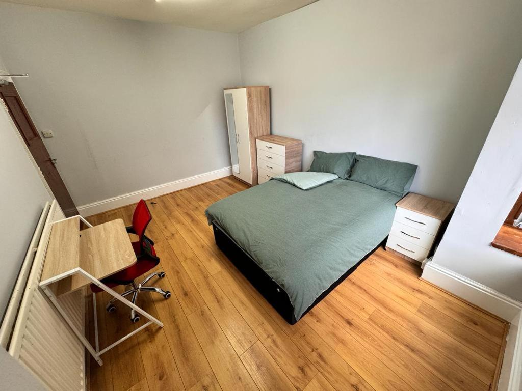 Habitación pequeña con cama y suelo de madera. en Langleys Private Double Room Selly Oak, en Birmingham