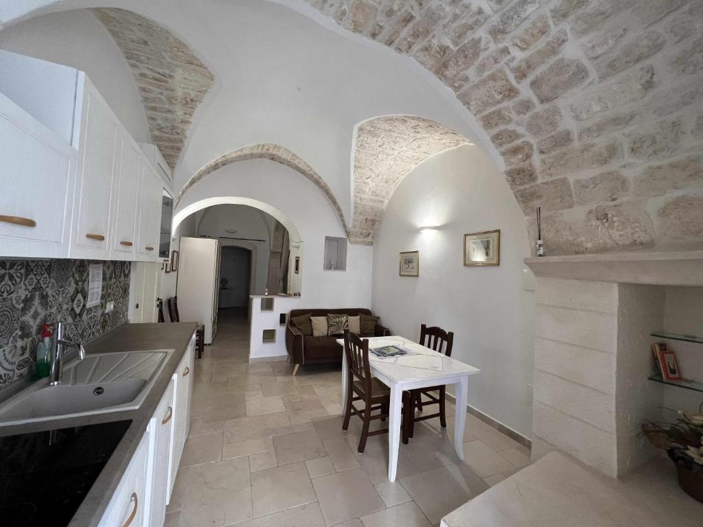 a kitchen and living room with a table and a couch at La Rosa D Ernesto WiFi free 3 sleeping places in Ostuni