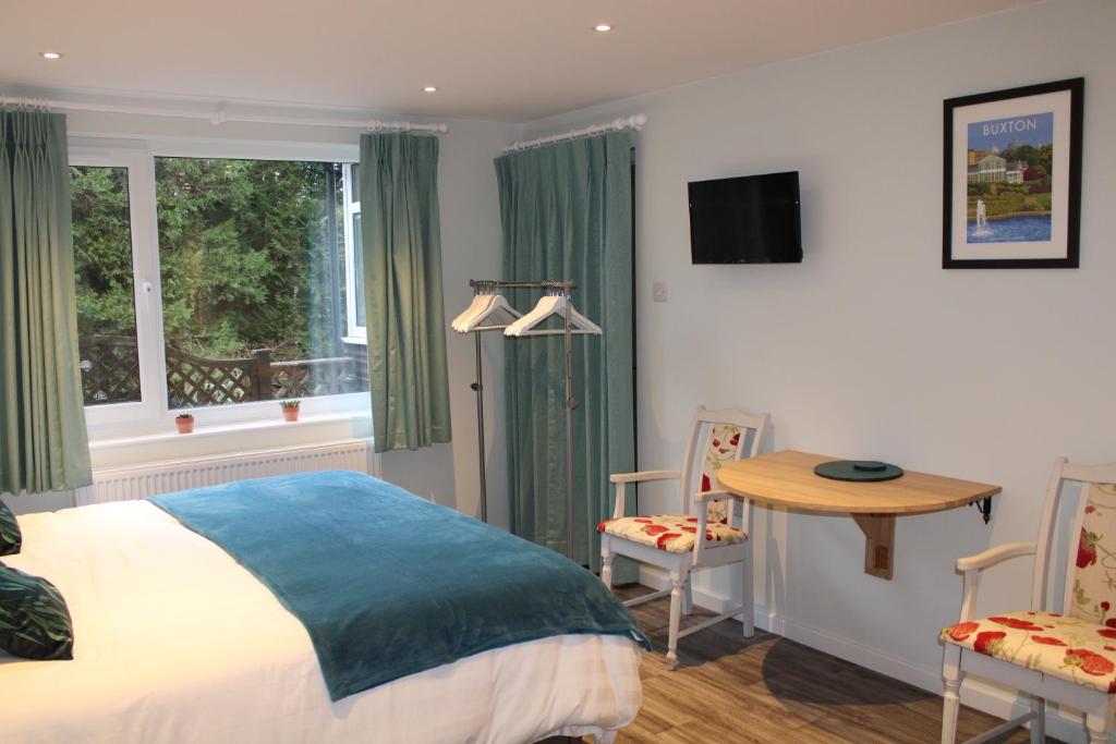 Schlafzimmer mit einem Bett, einem Tisch und Stühlen in der Unterkunft Level 15 Accommodation in Buxton