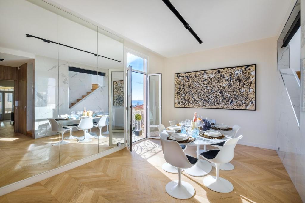 une salle à manger avec une table et des chaises blanches dans l'établissement Appartement de luxe - Bluesky, à Beausoleil