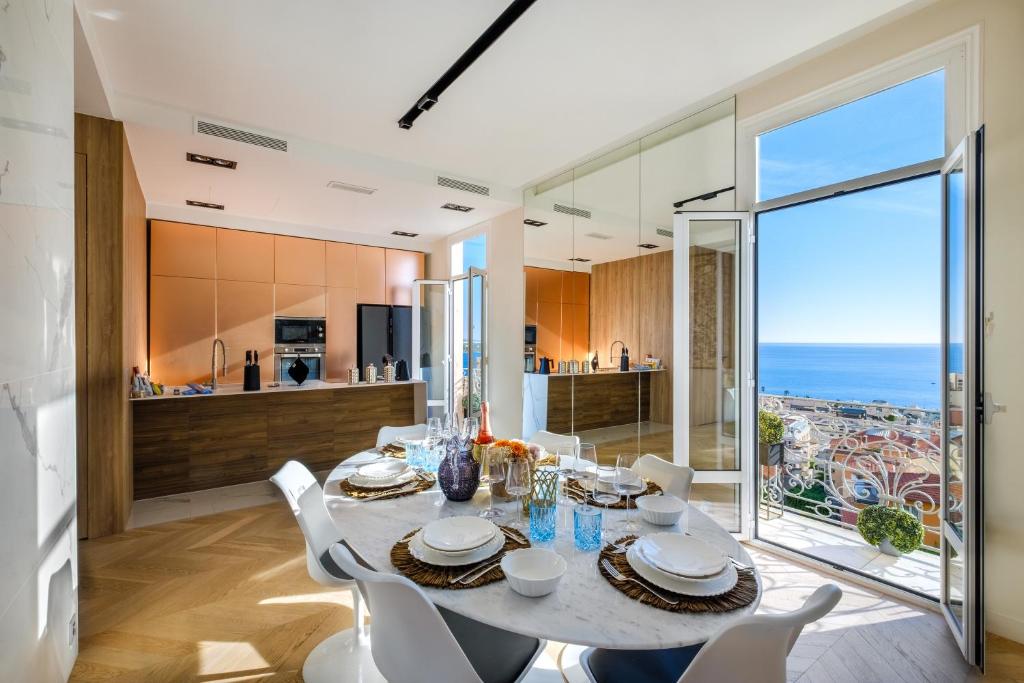 a kitchen and dining room with a table and chairs at Appartement de luxe bluesky in Beausoleil