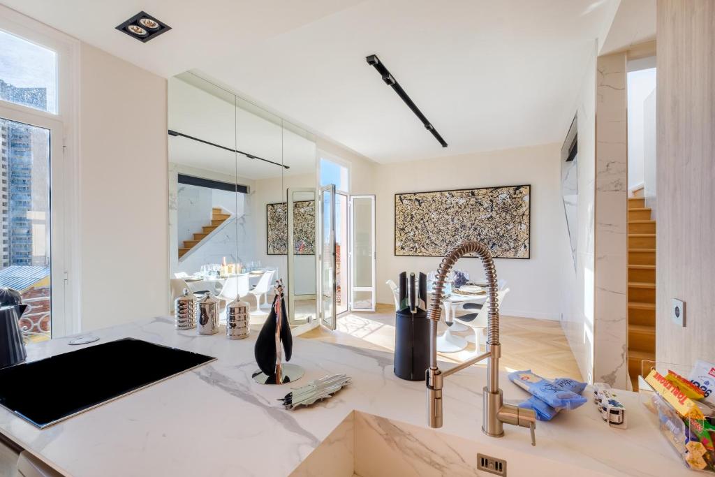 eine Küche mit einem Waschbecken und einem Spiegel in der Unterkunft Appartement de luxe bluesky in Beausoleil