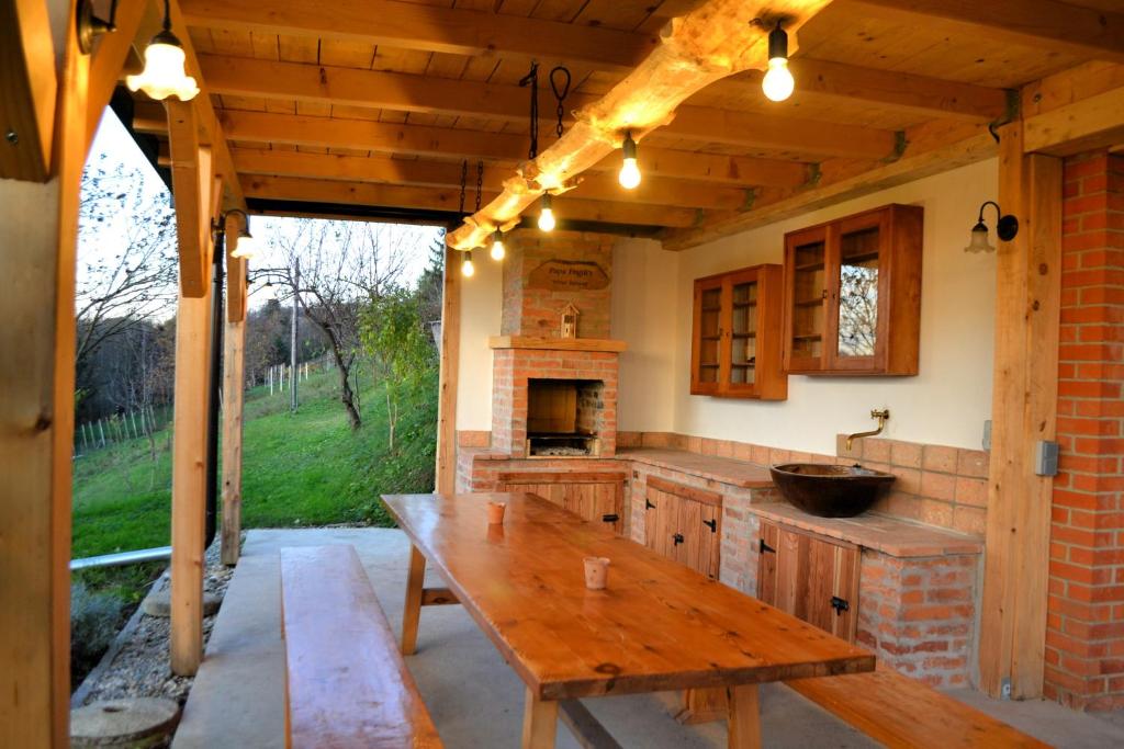 a kitchen with a wooden table and a fireplace at Papa Franks House in Ptuj