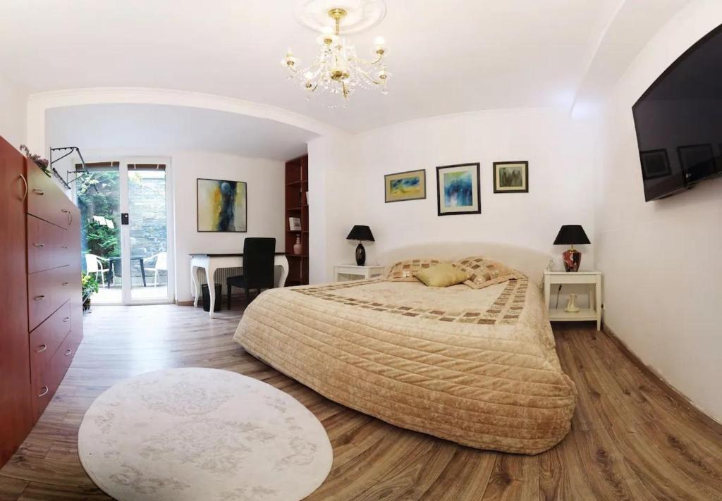 um quarto com uma cama grande e uma mesa em Cosy Studio with Garden Near the Prague Airport 