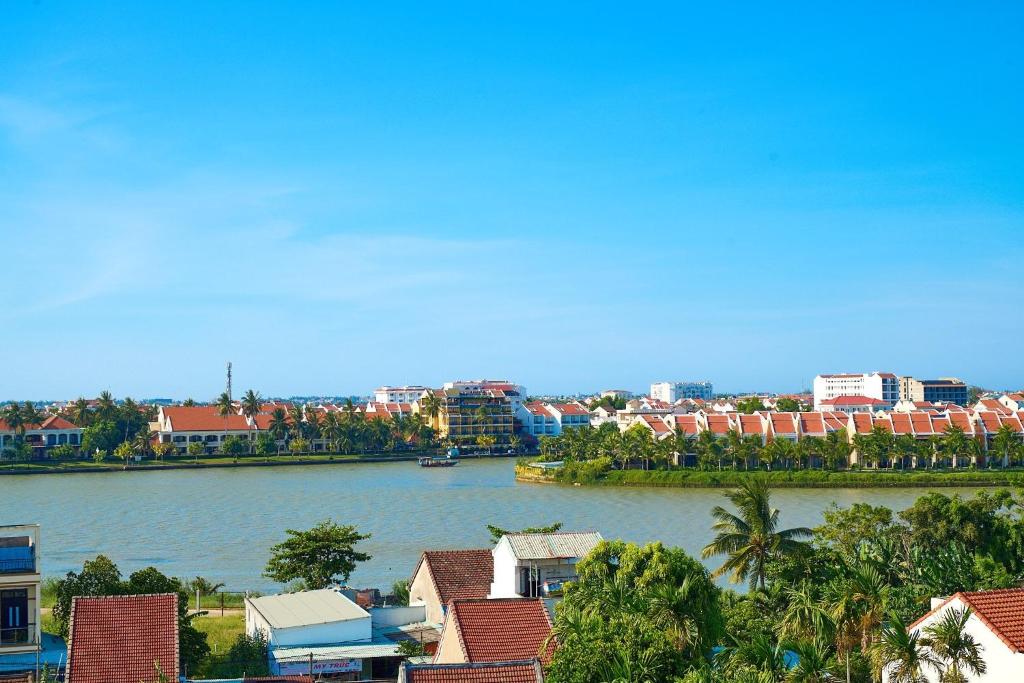 uitzicht op een rivier met huizen en gebouwen bij Legend Ancient Town Hoi An Hotel in Hội An