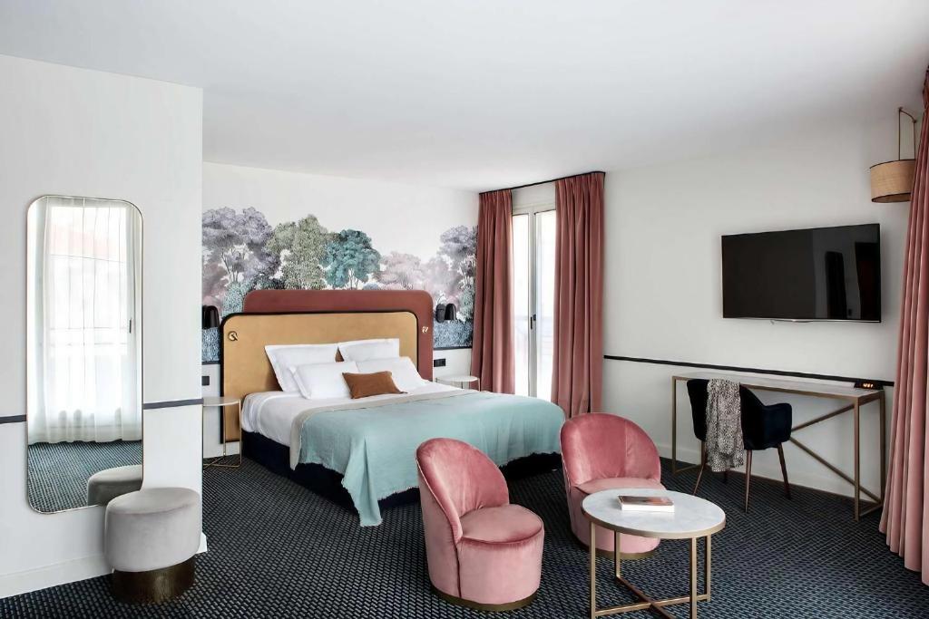 een slaapkamer met een bed met roze stoelen en een televisie bij Best Western Hotel du Pont Wilson in Lyon