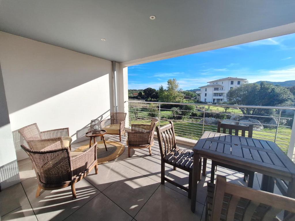 un balcon avec des chaises et une table et une vue dans l'établissement Domaine d'Arca - Flaubert 12 - 4 pers - étage 1, à Porto-Vecchio