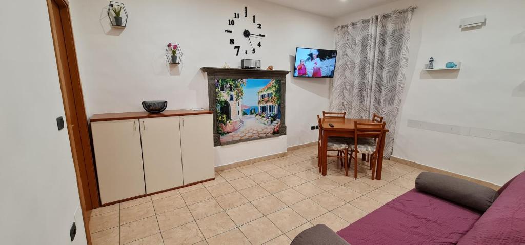 ein Wohnzimmer mit einem lila Sofa und einem Tisch in der Unterkunft La Casetta di Flò - Alloggio per Turisti in Marta