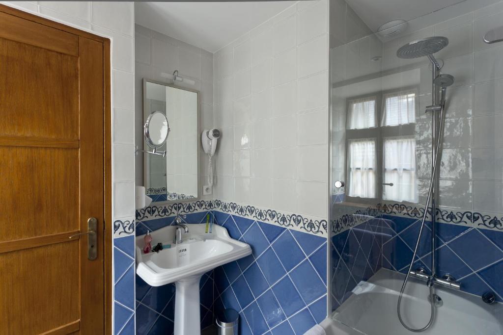 a blue and white bathroom with a sink and a shower at Auberge Saint Pierre in Le Mont Saint Michel
