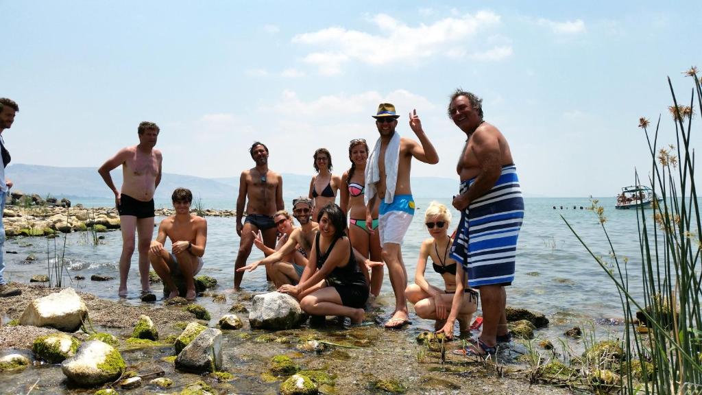a group of people standing in the water on the beach at Tiberias Hostel in Tiberias