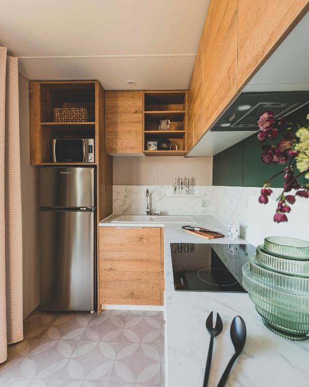 a kitchen with wooden cabinets and a stainless steel refrigerator at Regenbogen Tossens in Butjadingen