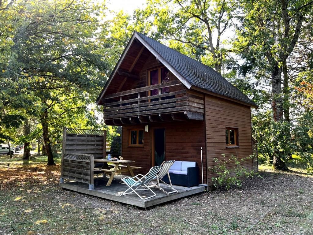 Cabaña pequeña con mesa y sillas frente a ella en La Rossignolerie - Gîte des châteaux, en Chouzy-sur-Cisse