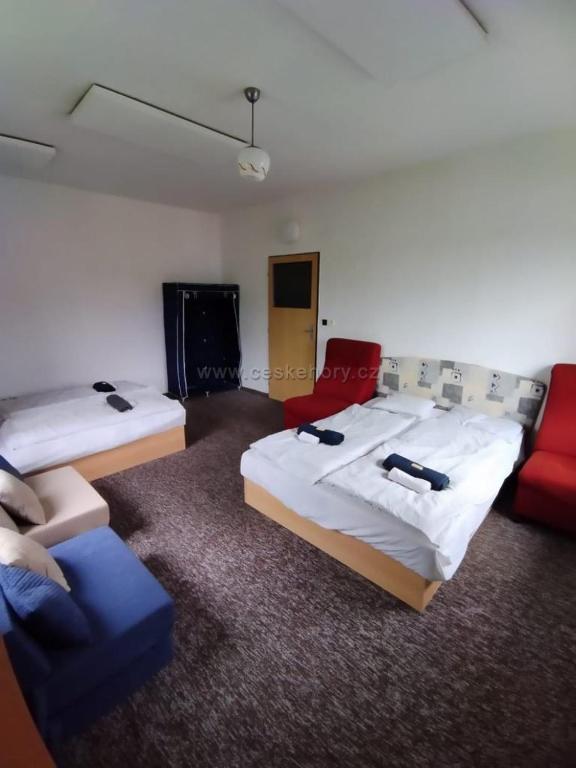 ein Hotelzimmer mit 2 Betten und einem Sofa in der Unterkunft Penzion Nikol in Šumperk