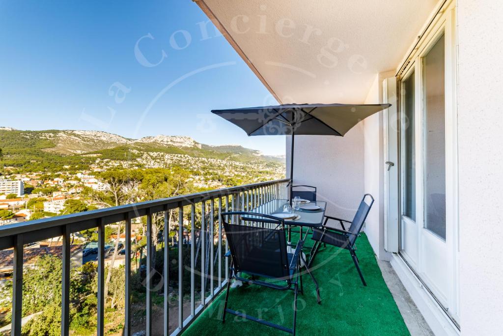 balcón con mesa, sillas y sombrilla en Appartement 4 personnes, en Toulon