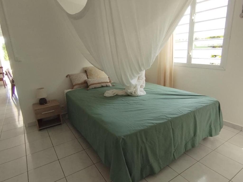 大博格Bas de villa vue mer avec deux chambres的一间卧室配有一张带天蓬的床