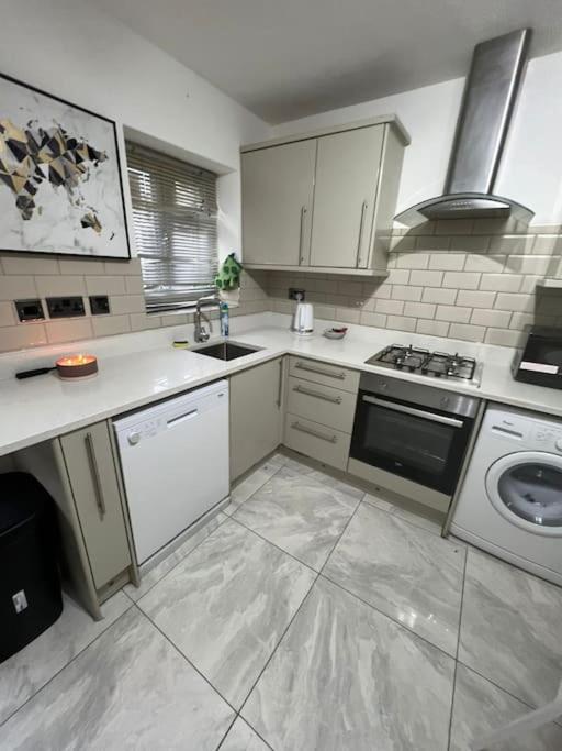 Il comprend une cuisine équipée d'un évier et d'une cuisinière. four supérieur dans l'établissement Beatle Luxy Apartment, à Feltham