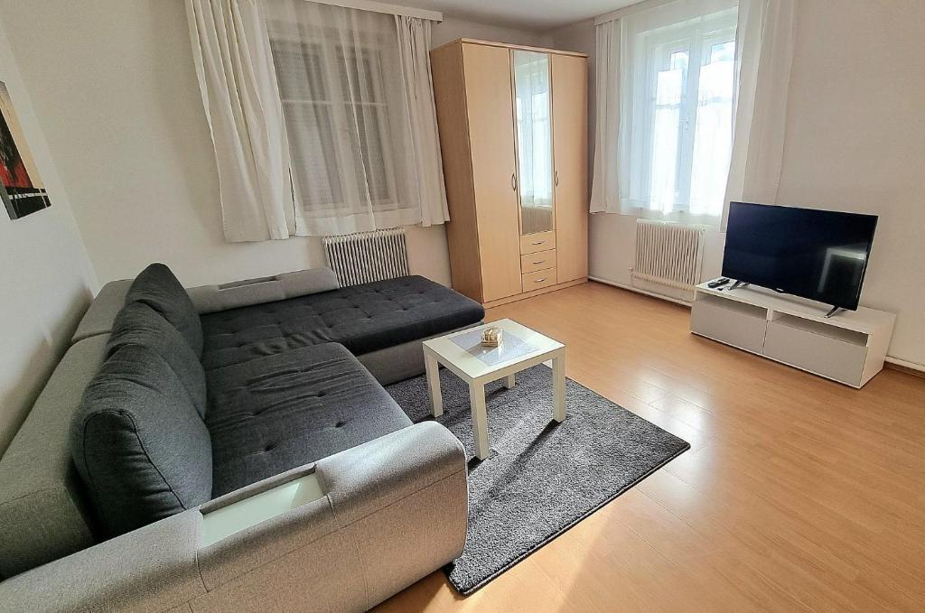 ein Wohnzimmer mit einem Sofa und einem TV in der Unterkunft Holiday Apartment 2 Villach in Villach
