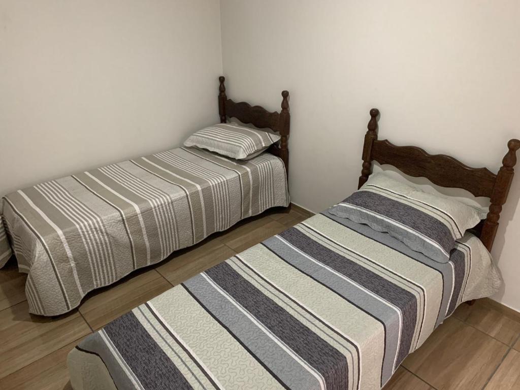 two beds sitting next to each other in a room at Apartamento Praia do Morro - Guarapari in Guarapari