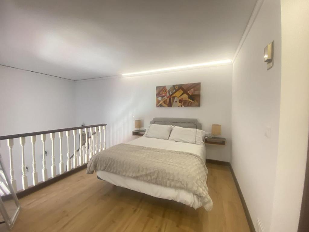 1 dormitorio con 1 cama en una habitación blanca en Edificio El Moderno Puerta del Sol, en Vigo