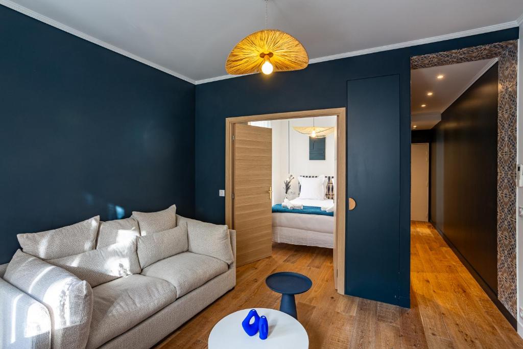 a living room with a couch and a bedroom at The Blue Suite Downtown Montmartre in Paris