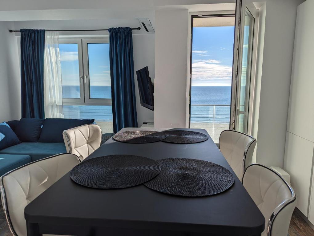 a living room with a black table and a couch at Black Sea Overlook in Mamaia Sat/Năvodari