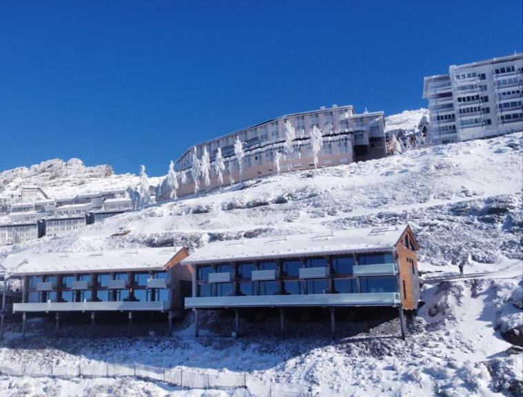 a building on top of a snow covered mountain at Lux 12 in Sierra Nevada