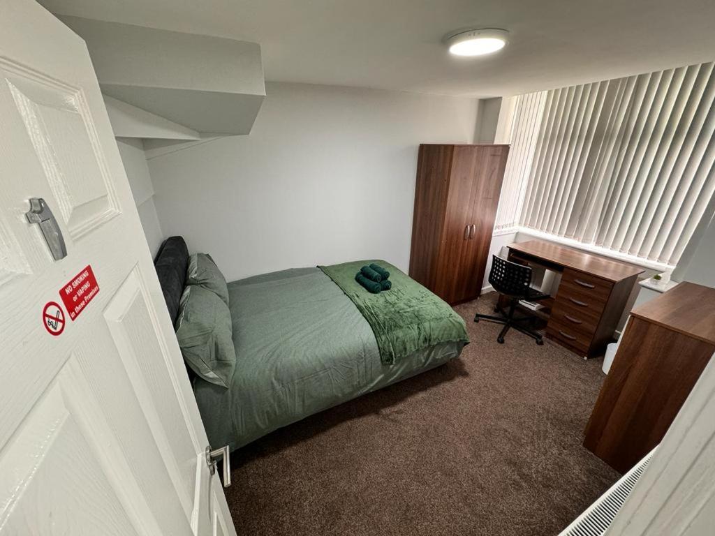 a bedroom with a bed and a desk in it at Seven Stars of Heeley Selly Oak in Birmingham