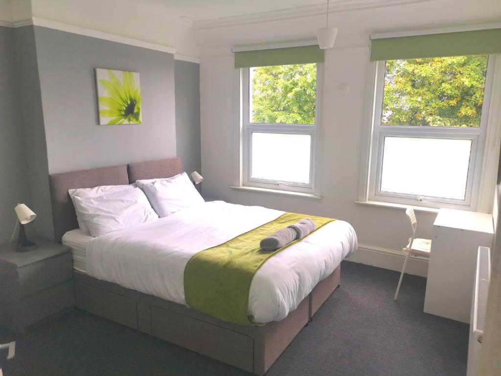 sypialnia z dużym łóżkiem i 2 oknami w obiekcie Amazing 2 bed London apartment w Londynie
