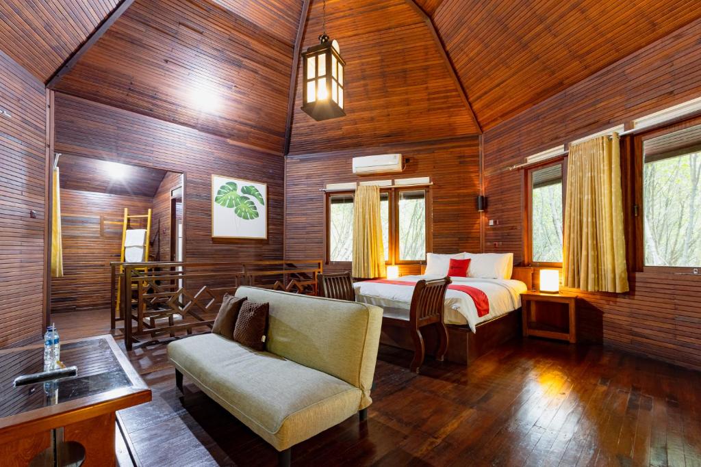 1 dormitorio con 1 cama y 1 silla en una habitación en RedDoorz Resort @ Taman Wisata Mangrove, en Yakarta