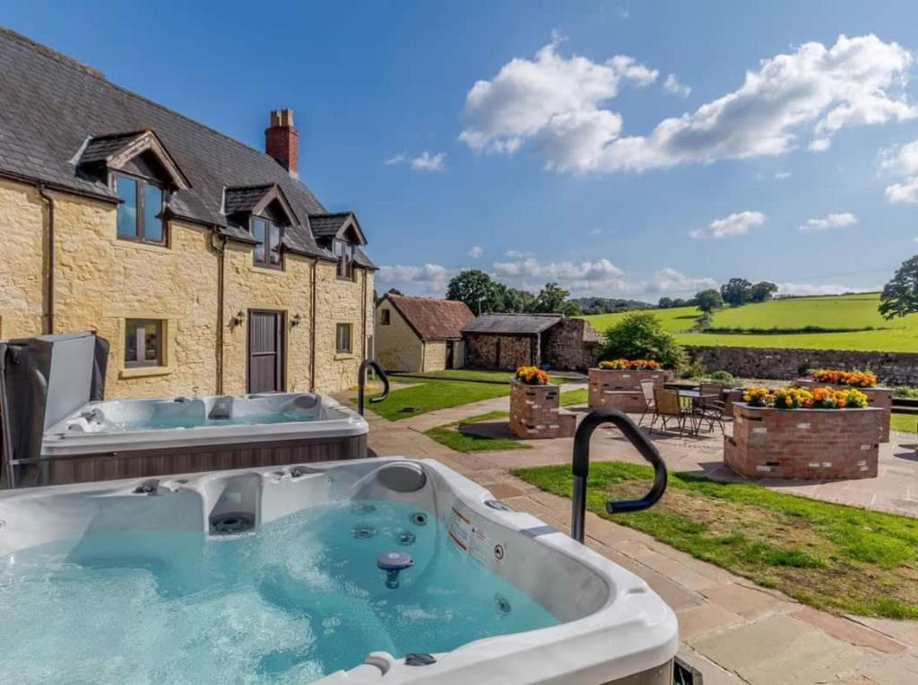 a hot tub in the backyard of a house at Henrhiw Farm Cottages in Usk