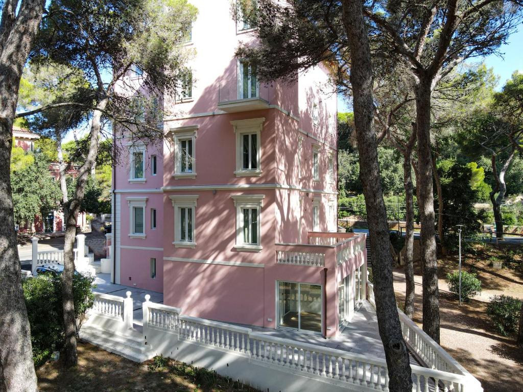 a pink house in the middle of trees at Castiglioncello Suite in Castiglioncello