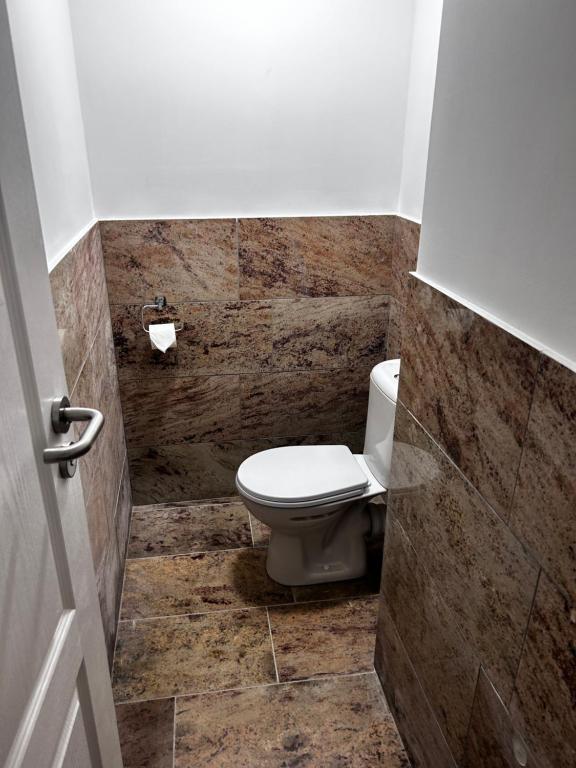 uma casa de banho com WC e piso em azulejo em Hostel 24 Miejsca Parkingowe Noclegi Pracownicze. em Gorzów Wielkopolski