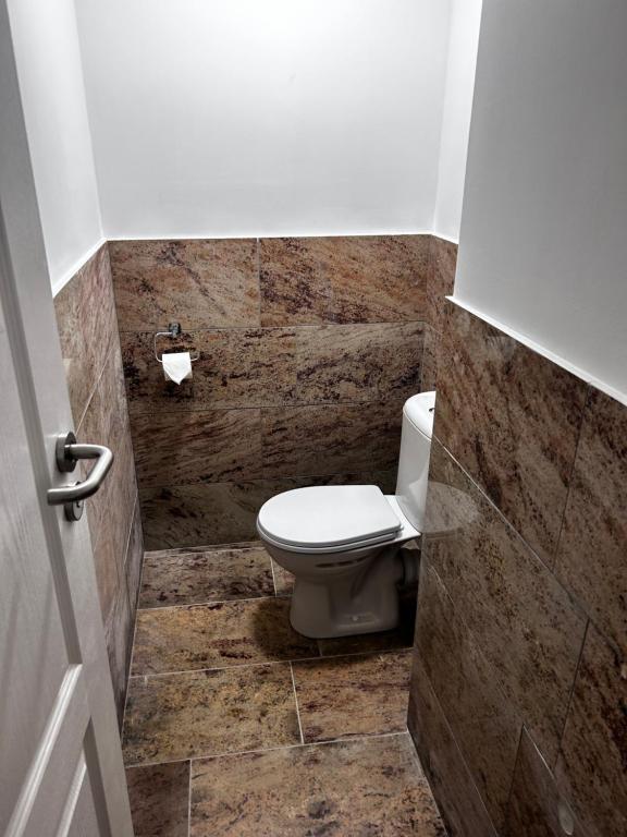 bagno con servizi igienici e pavimento piastrellato. di Hostel 24 Miejsca Parkingowe Noclegi Pracownicze. a Gorzów Wielkopolski
