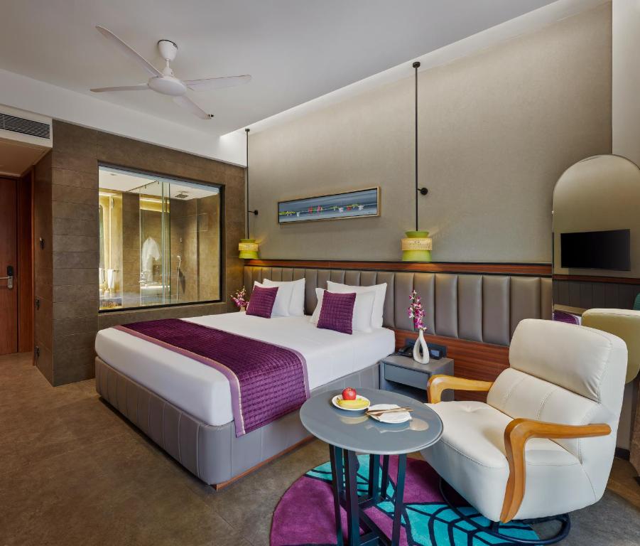 Pokój hotelowy z łóżkiem i krzesłem w obiekcie Moyrah By Greenpark w mieście Anjuna