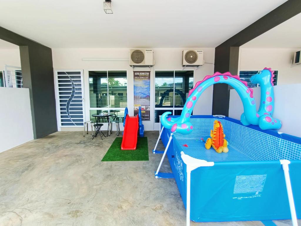 una sala de juegos para niños con un tobogán y un juego de juegos en ASFA Homestay Kuching en Kuching