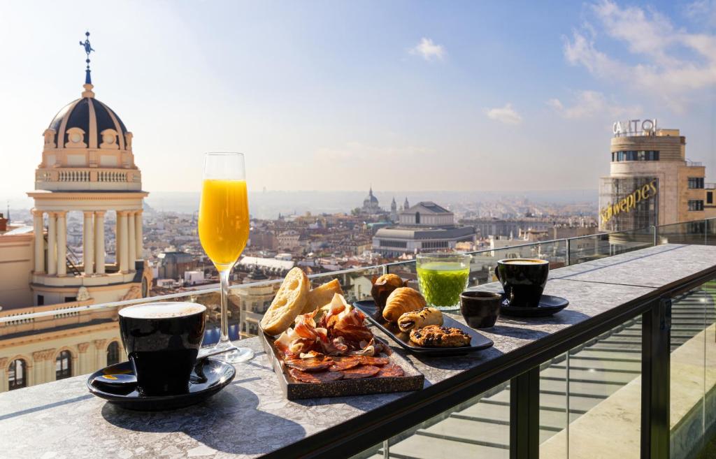 a table with a plate of food and a glass of beer at Smartrental Collection Gran Vía Centric in Madrid