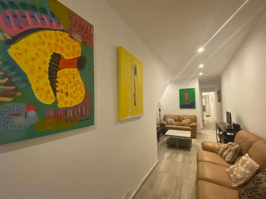 a living room with a couch and a painting on the wall at Beach House. Live, experience sea in St. Paul's Bay