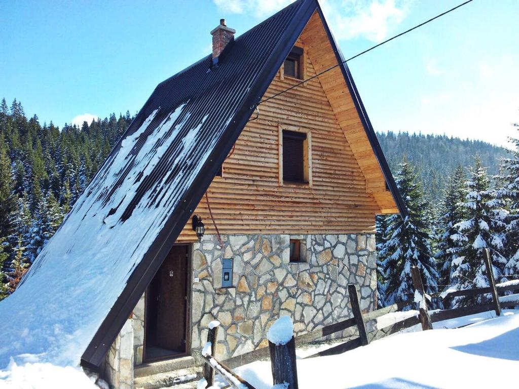 a small wooden cabin with a roof in the snow at Vikendice Jahorinska Dvorišta in Pale