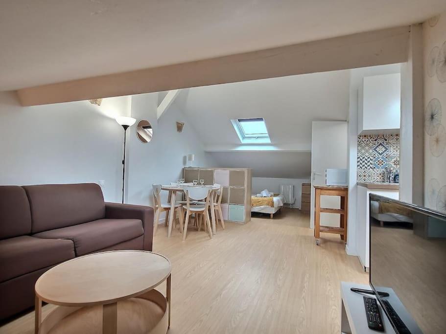 a living room with a couch and a table at Au bord du canal G *Paris*Disney*Gare* in Chelles