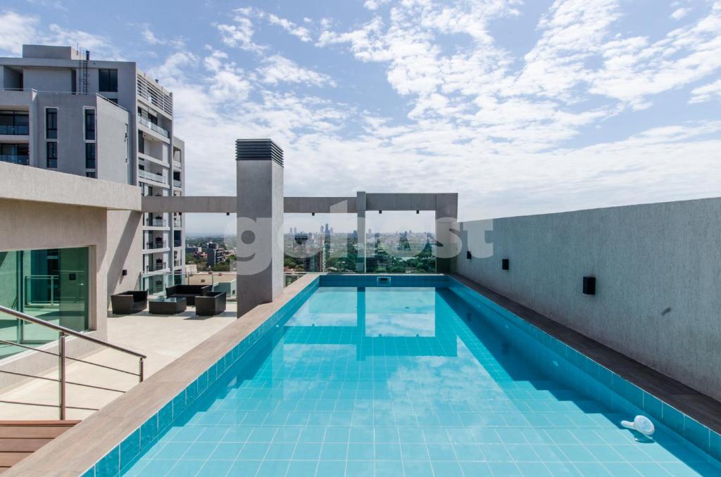 una piscina en la azotea de un edificio en Comfortable Apartment Close To Shopping Mariscal, en Asunción
