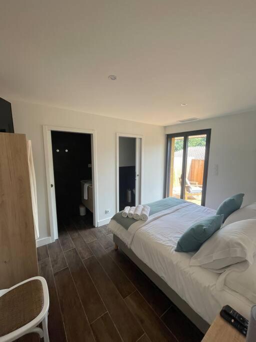 une chambre avec un grand lit et une fenêtre dans l'établissement Petite maison proche de la plage, à Lège-Cap-Ferret