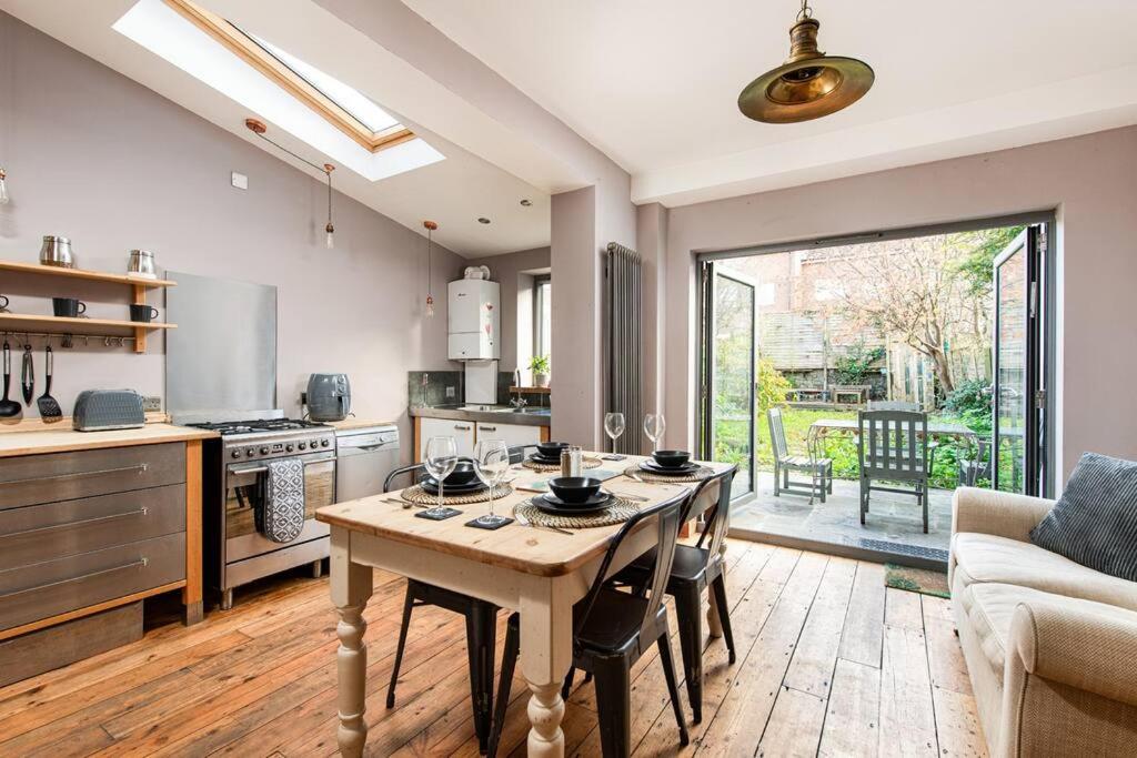 a kitchen with a table with chairs and a couch at AJ's Stays - FREE WIFI - FREE PARKING - GARDEN - SLEEPS UP TO 7 - 4 BEDS in Bristol
