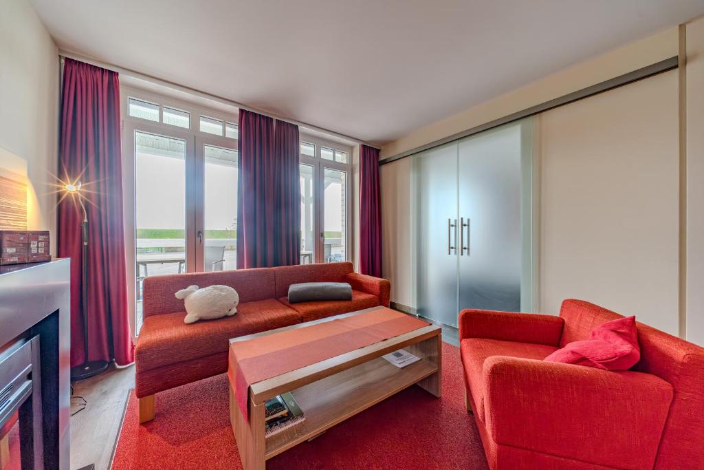 un soggiorno con divano e 2 sedie di Resort Deichgraf Resort Deichgraf 27-08 a Wremen