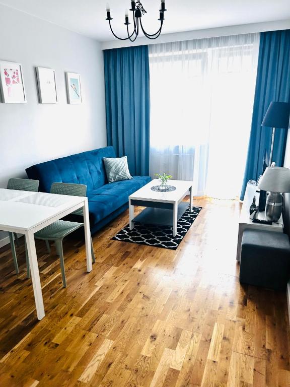 sala de estar con sofá azul y mesa en Apartament Manhattan, en Gorzów Wielkopolski